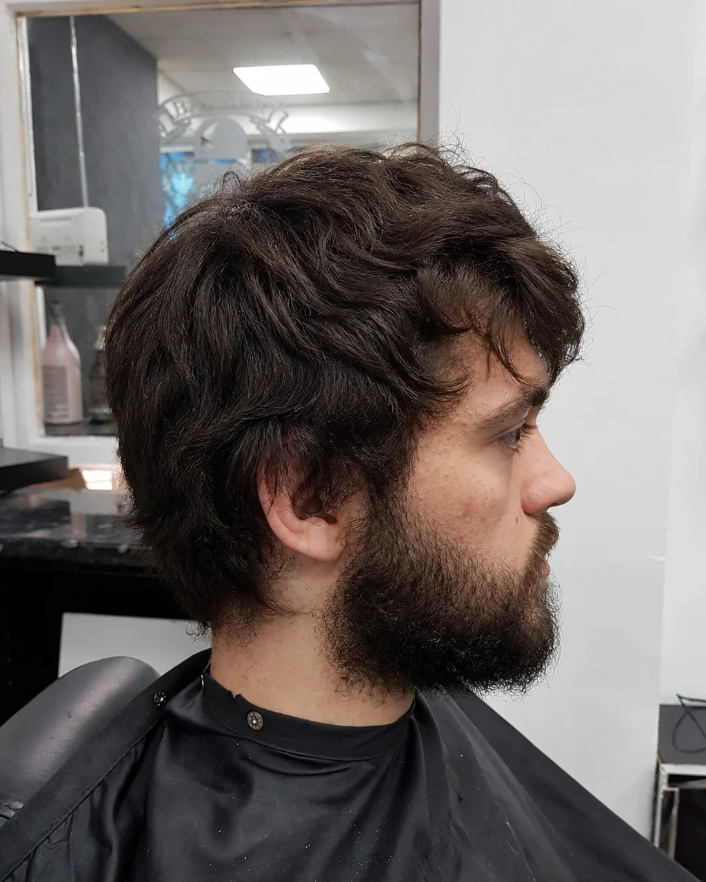 Client with shaggy overgrown hair and untrimmed beard before his cut