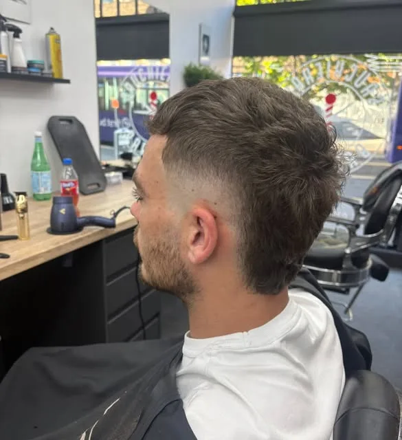 Textured cut with a low fade, shot from the side in the shop