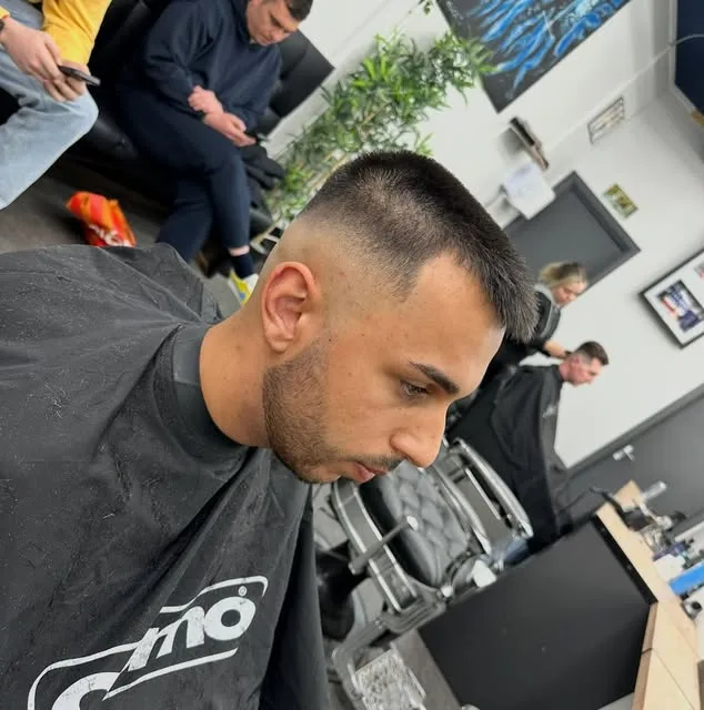 Sharp skin fade blend, side profile at the Sauchiehall Barbers window