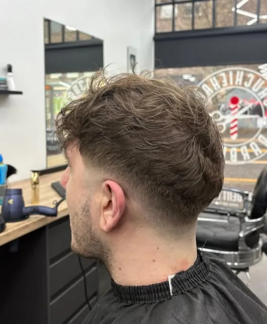 Messy textured crop with a low taper, barber pole decal in the window behind