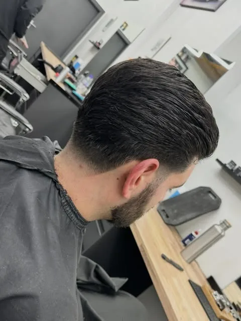 Slicked-back cut with a tapered neckline at Sauchiehall Barbers