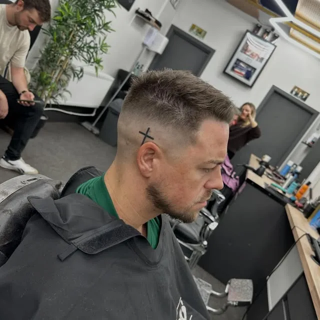 Skin fade with a cross hair design and shaped beard at Sauchiehall Barbers