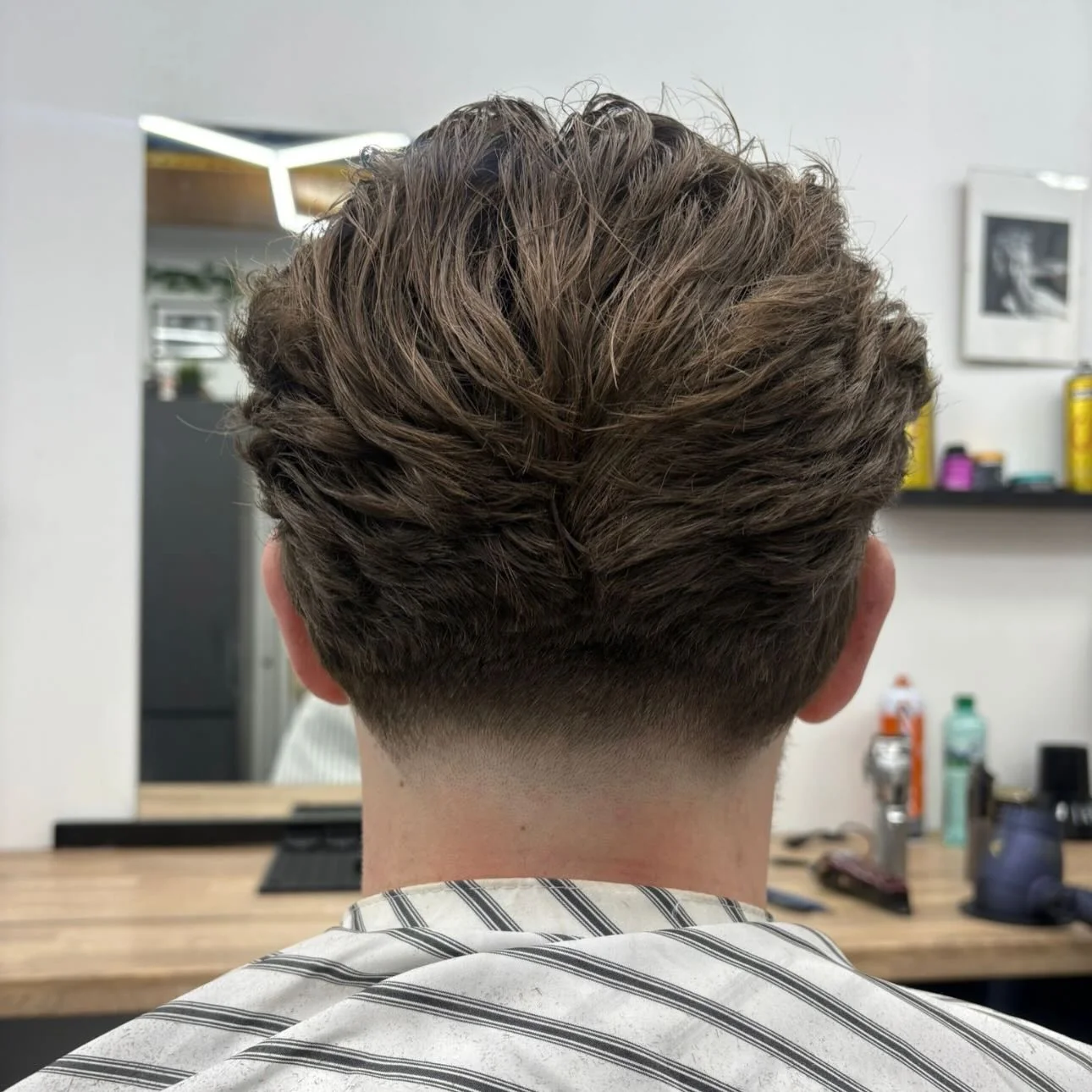Textured crop finished with a low taper, straight-on back view