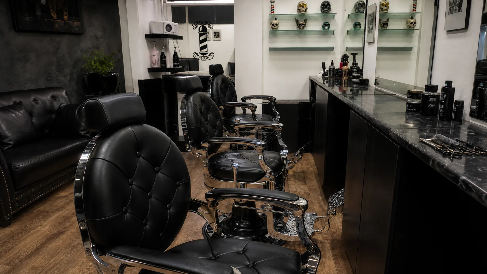 Inside Sauchiehall Barbers: traditional black tufted barber chairs with chrome frames, large mirrors and working stations